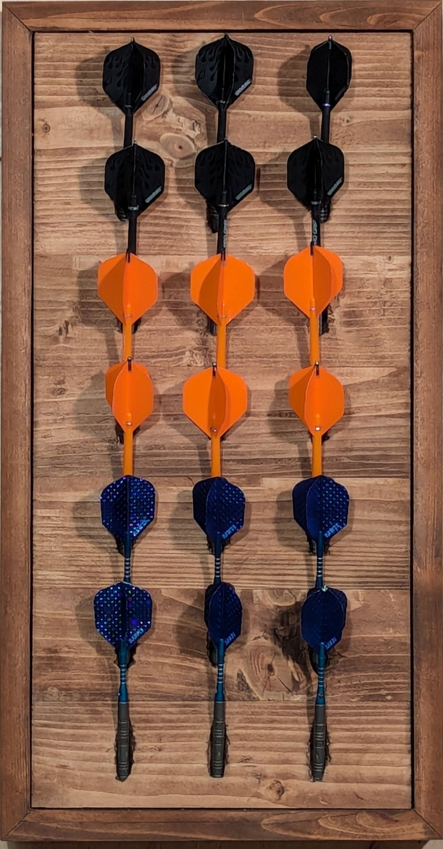 Display your darts on this solid pine darts holder finished with a Special Oak stain. Accommodates 6 sets of darts (8 darts).